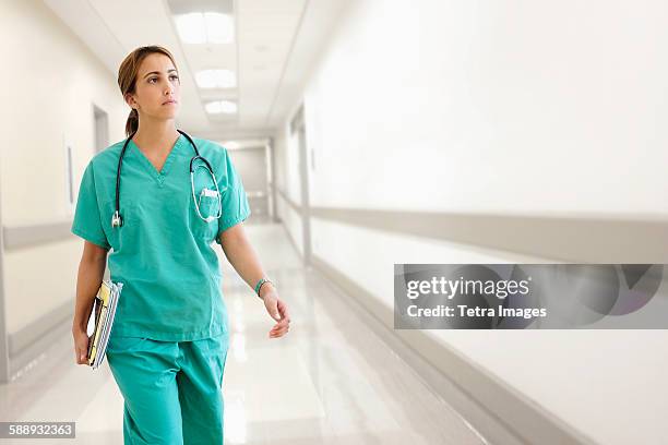 young female doctor in hospital corridor - encuadre de tres cuartos fotografías e imágenes de stock