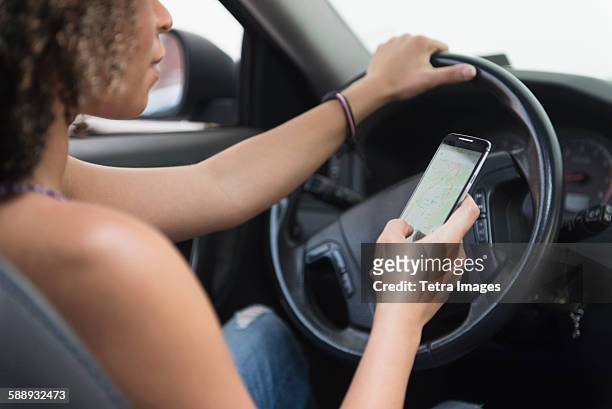 young woman texting while driving car - one young woman only texting foto e immagini stock