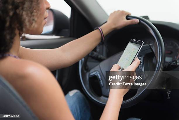 young woman texting while driving car - inside car stock pictures, royalty-free photos & images