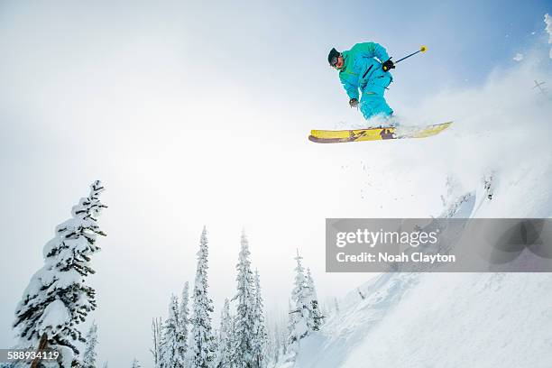 young man jumping from ski slope - whitefish montana stockfoto's en -beelden