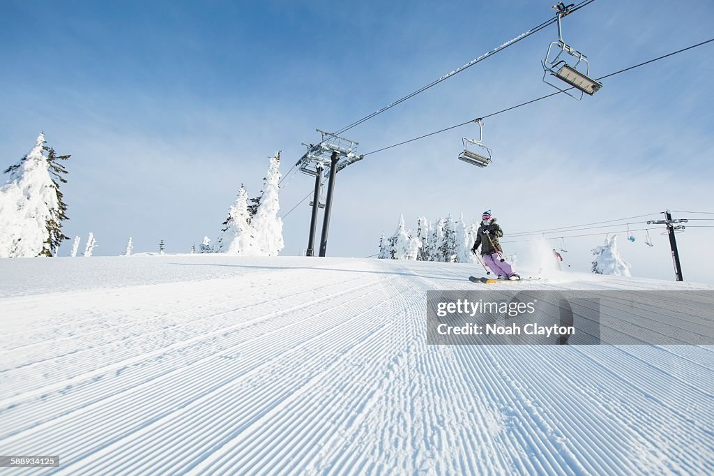 Mid-adult woman on ski slope under cable car