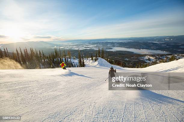 two people on ski slope at sunlight - ski hill stock pictures, royalty-free photos & images