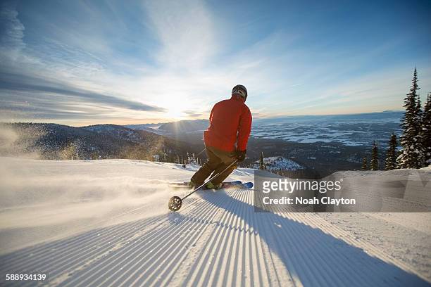 mature man on ski slope at sunset - wintersport stock-fotos und bilder