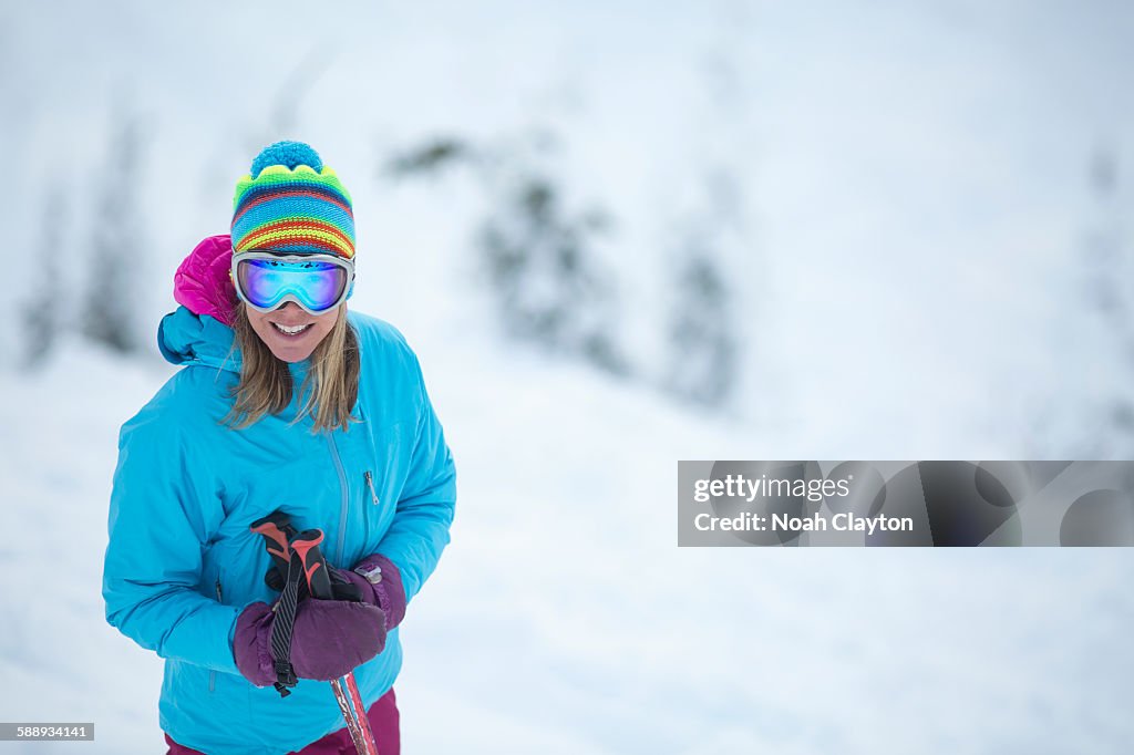 Smiley woman wearing skiwear on ski slope