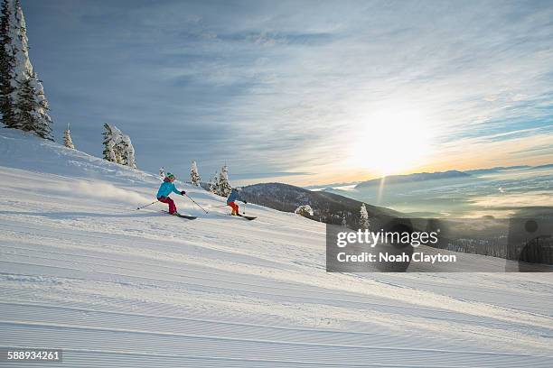 couple skiing at sunset - whitefish montana stock pictures, royalty-free photos & images