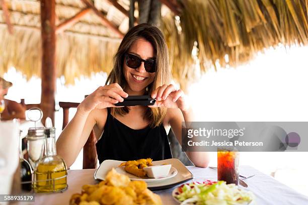 woman by table, using phone - dominican republic stock pictures, royalty-free photos & images