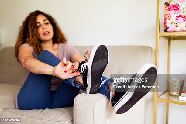 woman putting on trainers - anziehen stock-fotos und bilder