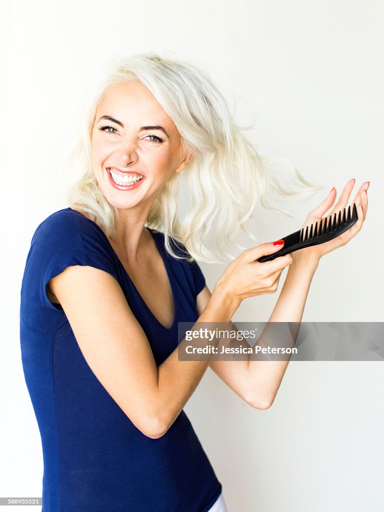Studio shot of woman combing hair