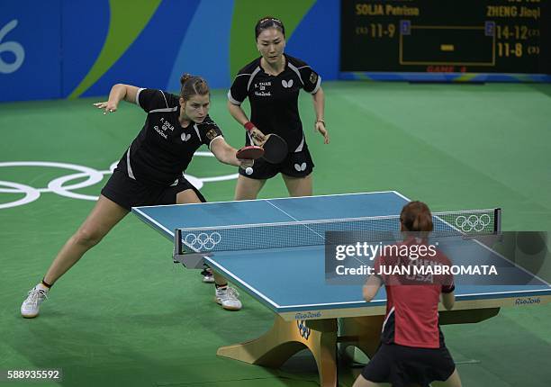 Germany's Petrissa Solja hits a shot next to Germany's Shan Xiaona in the women's team qualification round table tennis match against USA's Zheng...