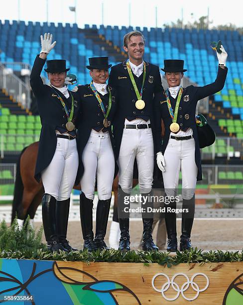 The German team of Isabell Werth, Dorothee Schneider, Sonke Rothenberger and Kristina Broring-Sprehe pose after winning the team gold during the...