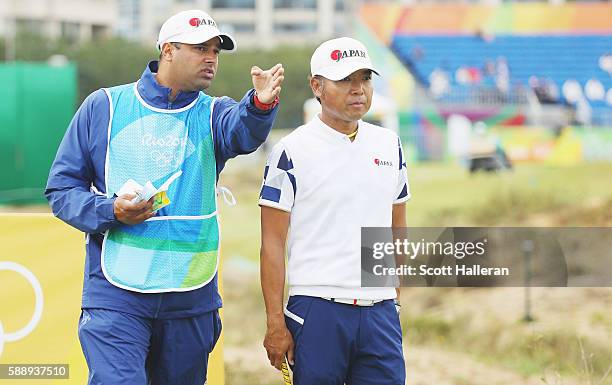 Shingo Katayama of Japan lines up his tee shot on the eighth hole with his caddie Rajiv Prasad during the second round of the golf on Day 7 of the...