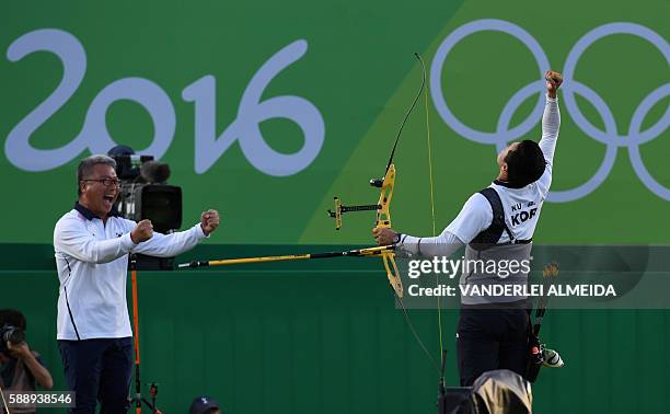 South Korea's archer Ku Bonchan celebrates with his coach after winning the final of the men's individual competition at the Sambodromo archery venue...