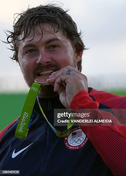 S bronze medalist archer Brady Ellison bites his medal on the podium during the medal ceremony of the men's individual competition at the Sambodromo...