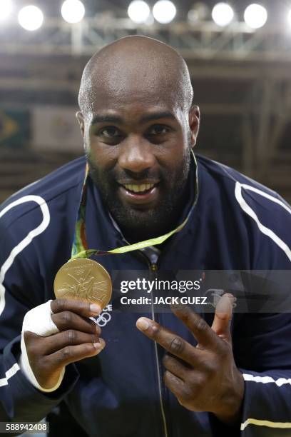 Gold medallist France's Teddy Riner celebrates with his medal after the podium ceremony of the men's +100kg judo contest of the Rio 2016 Olympic...