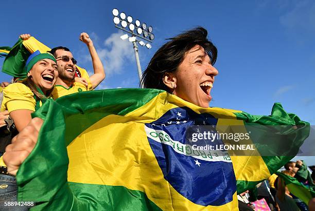 Supporters of Brazil celebrate after their team won the women's beach volleyball round of 16 match between Germany and Brazil at the Beach Volley...