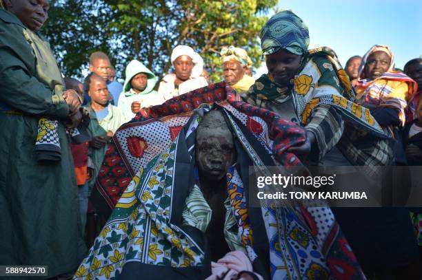 Young initiate receives colourful wrappers as a reward after succesfully undergoing a traditional circumcission rite at his village in Kenya's...