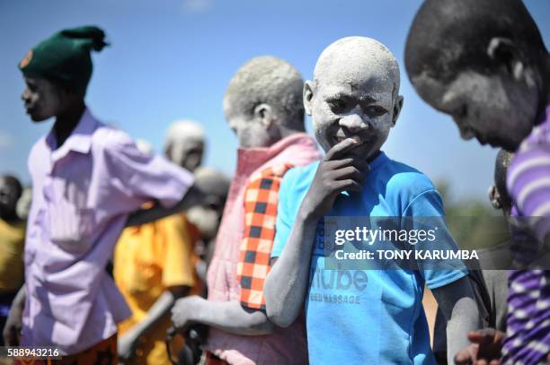 Young boy wearing ceremonial ash smiles after succesfully undergoing a traditional circumcission rite at his village in Kenya's western county of...