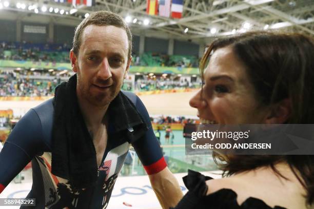 Britain's Bradley Wiggins speaks to his wife Catherine Wiggins after winning gold in the men's Team Pursuit finals track cycling event at the...