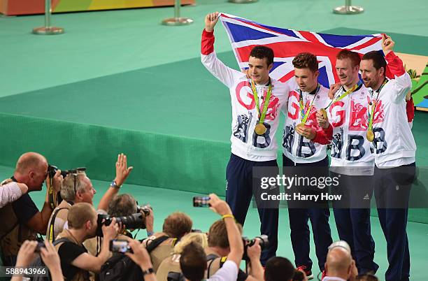 Gold medalists Steven Burke, Owain Doull, Edward Clancy and Bradley Wiggins of Team Great Britain pose for photographs after at the medal ceremony...