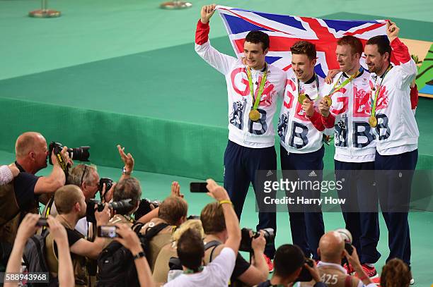 Gold medalists Steven Burke, Owain Doull, Edward Clancy and Bradley Wiggins of Team Great Britain pose for photographs after at the medal ceremony...