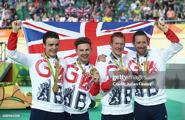 Gold medalists Steven Burke, Owain Doull, Edward Clancy and Bradley Wiggins of Team Great Britain pose for photographs after at the medal ceremony...