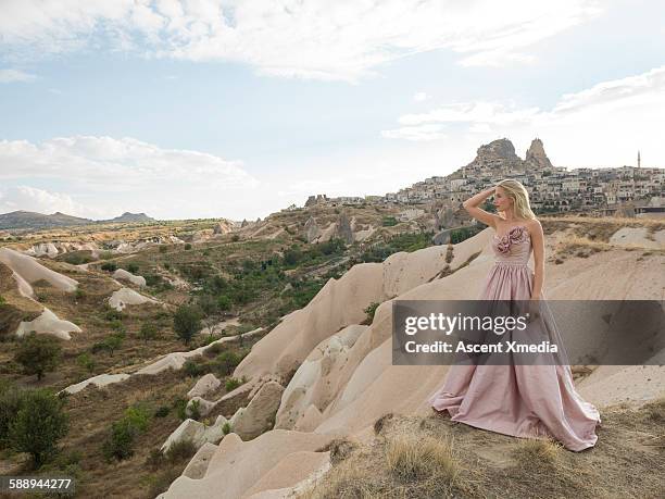 haute couture model poses above desert landscape - strapless evening gown foto e immagini stock