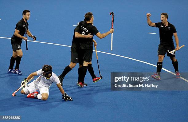 Kane Russell, Nic Woods, Nick Wilson, Simon Child of New Zealand reacand t to a goal as Arthur van Doren of Belgium looks on during a Men's...