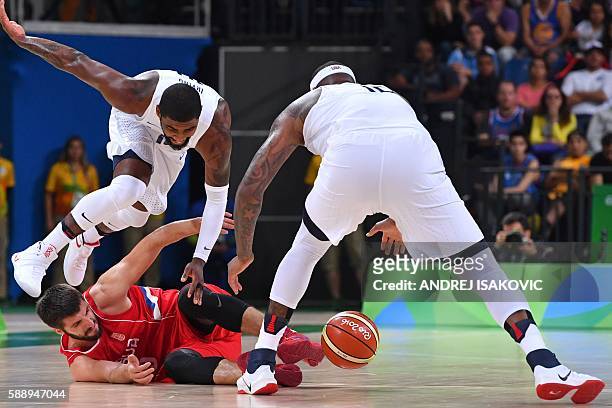 S guard Kyrie Irving jumps over Serbia's point guard Stefan Markovic as USA's centre DeMarcus Cousins grabs the ball during a Men's round Group A...