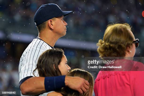 Alex Rodriguez of the New York Yankees stands with his daughters Natasha, Ella and his mother Lourdes Rodriguez during a presentation in his honor...