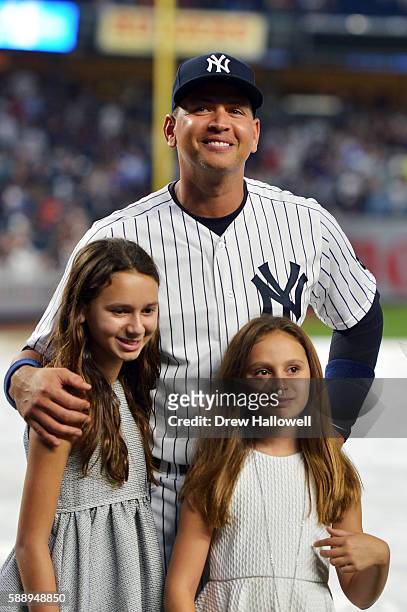 Alex Rodriguez of the New York Yankees stands with his daughters Natasha and Ella during a presentation in his honor before the game against the...