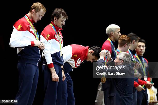 President Thomas Bach presents Artur Akhmatkhuzin of Russia with a gold medal during the podium celebration for the Men's Team Foil event on Day 7 of...