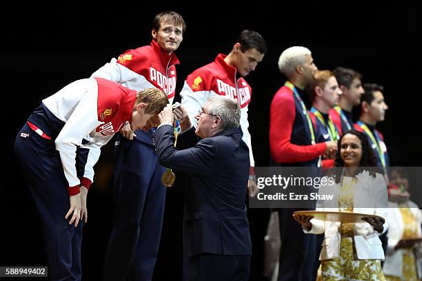 President Thomas Bach presents Artur Akhmatkhuzin of Russia with a gold medal during the podium celebration for the Men's Team Foil event on Day 7 of...