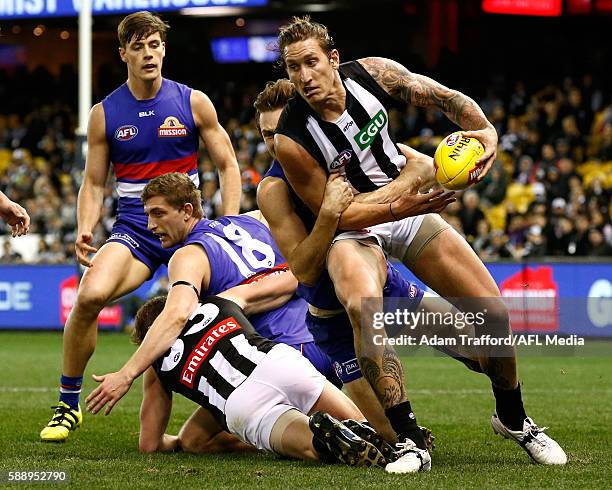 Jesse White of the Magpies is tackled by Joel Hamling of the Bulldogs during the 2016 AFL Round 21 match between the Western Bulldogs and the...