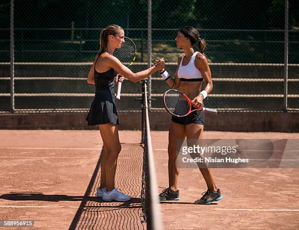 two women tennis players shaking hands after match - competition round photos et images de collection