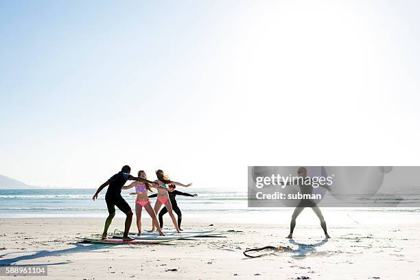 surf instructor giving surf lessons on the beach - surf stockfoto's en -beelden