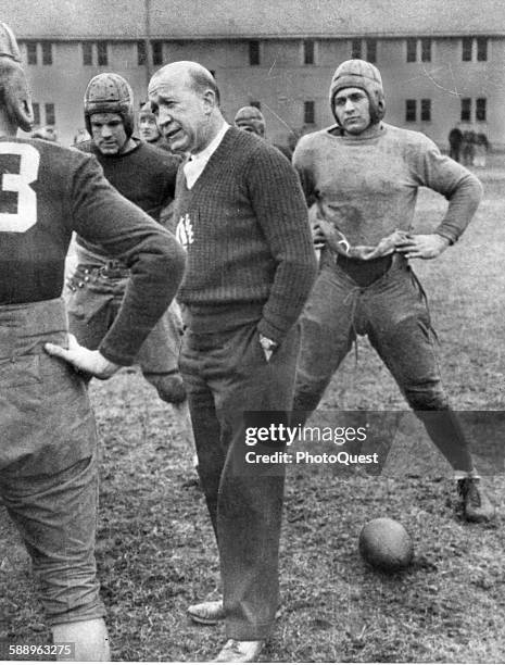 As shown in this picture with his squad, Notre Dame University football coach Knute Rockne discusses fundamentals with his players, South Bend,...