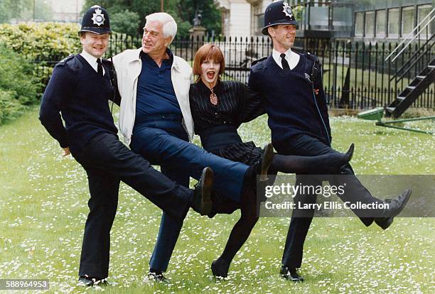 Canadian American actor and comedian Leslie Nielsen dancing with actress Priscilla Presley and two policemen , UK, 1994. Nielsen and Presley starred...