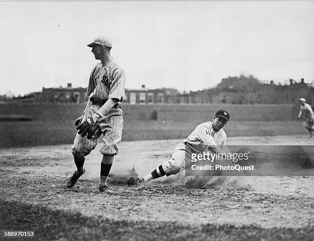 Washington Senators' Bucky Harris slides as he successfully steals third base in the 7th inning of a baseball game against the Boston Red Sox; third...