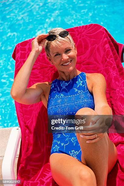 woman relaxing on pool chair - middle aged woman bathing suit stock pictures, royalty-free photos & images