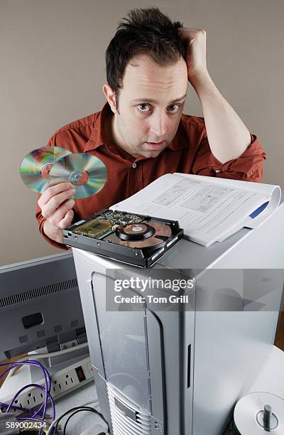 confused man working on computer - computer repair stock pictures, royalty-free photos & images