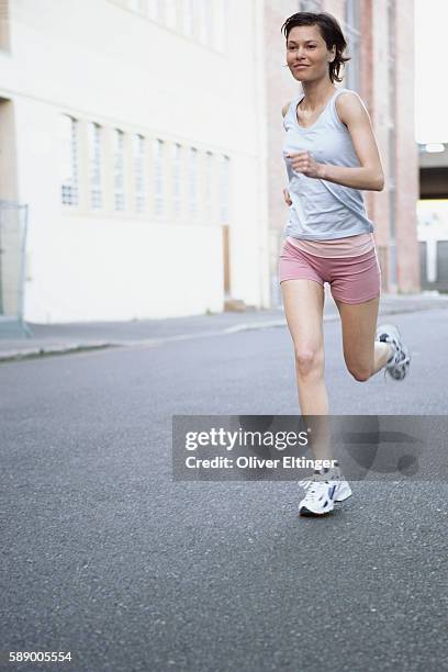 woman running on city street - oliver eltinger stock pictures, royalty-free photos & images