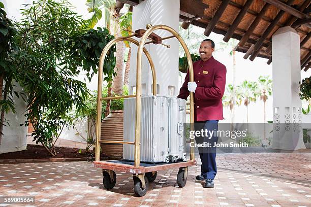 bellhop with luggage - carrito-para-equipaje fotografías e imágenes de stock