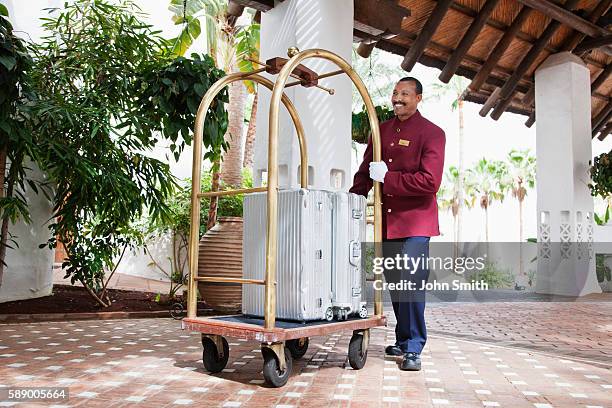 bellhop with luggage - luggage trolley stock pictures, royalty-free photos & images