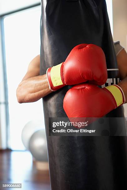 man hugging punching bag - oliver eltinger stock pictures, royalty-free photos & images