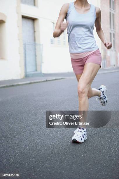 woman running on street - oliver eltinger stock pictures, royalty-free photos & images