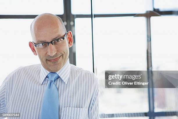 bald businessman smiling - oliver eltinger stock pictures, royalty-free photos & images