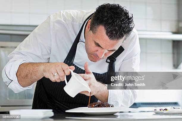 male chef preparing meal in kitchen - pouring sauce stock pictures, royalty-free photos & images