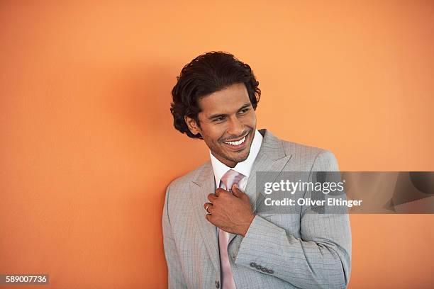 smiling businessman adjusting his tie - oliver eltinger stock pictures, royalty-free photos & images