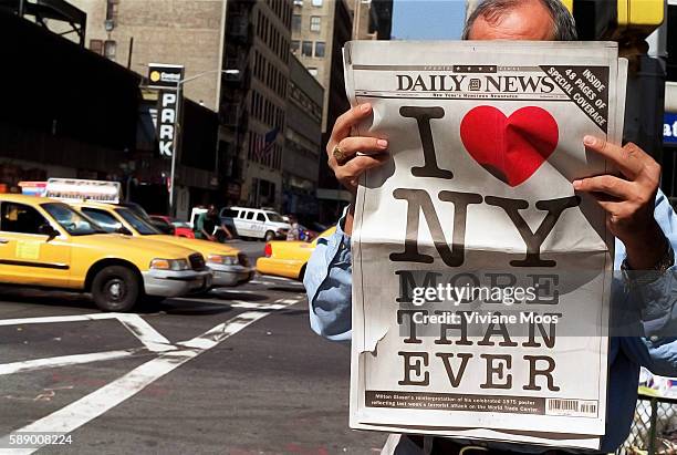 After the terrorist attack that leveled the World Trade Center, New Yorkers show their love for the city. A man on the street reading the back page...