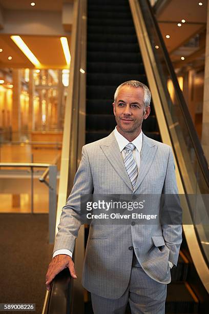 businessman on escalator - oliver eltinger stock-fotos und bilder